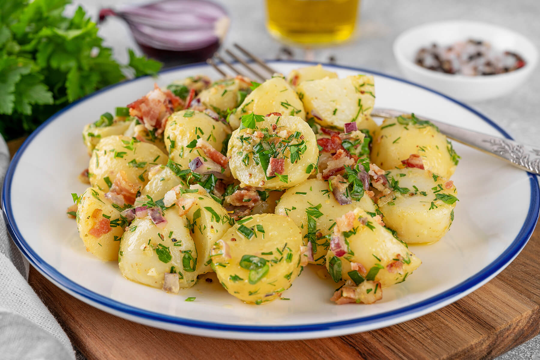 Warmer Kartoffelsalat mit Speck und Kräutern in der Schüssel