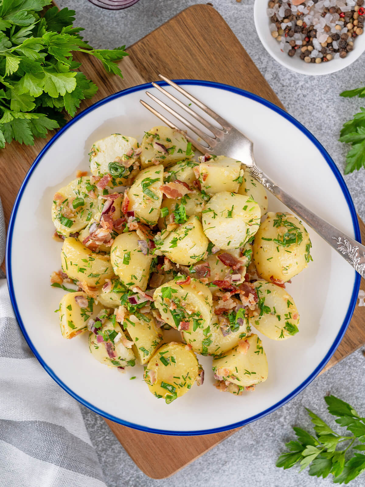 Nahaufnahme glänzender Kartoffelscheiben mit Speck und Kräutern