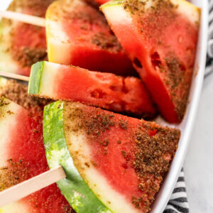 Wassermelonen-Pops am Holzstiel mit Chili-Limetten-Rand auf einem Teller