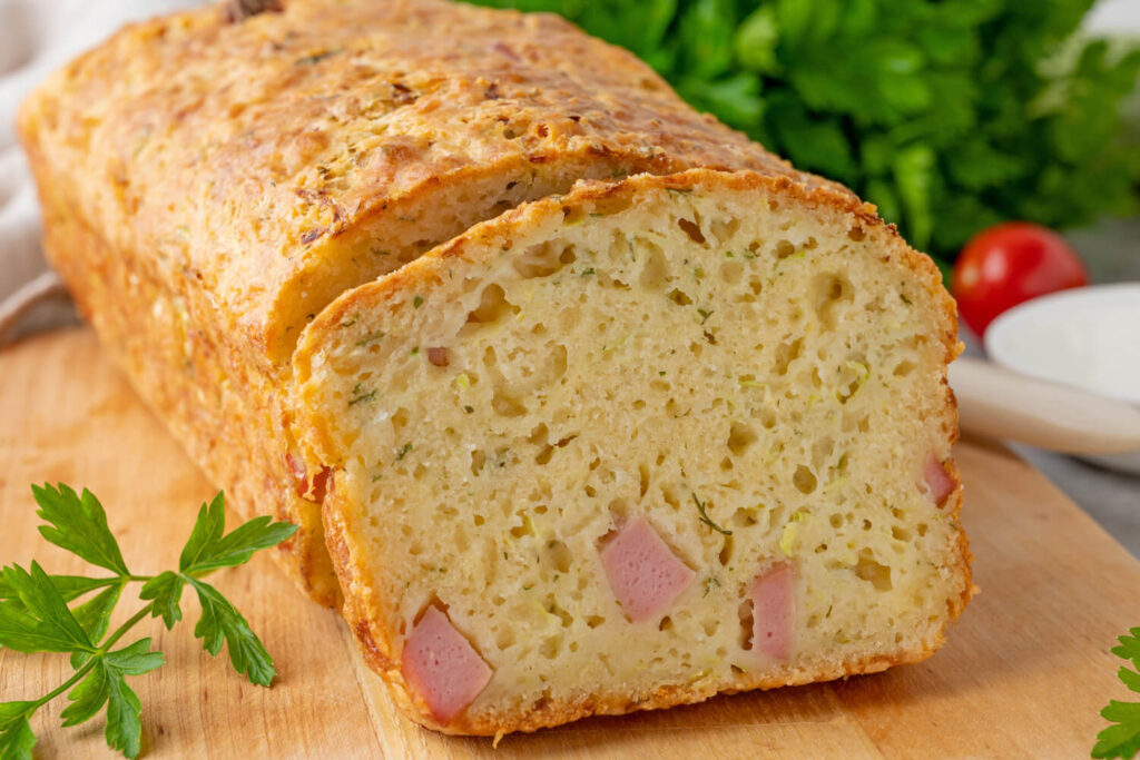 Herzhaftes Zucchini-Käse-Schinken-Brot auf Holzbrett