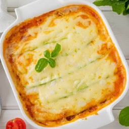 Zucchini-Lasagne Stück auf Teller mit Basilikum