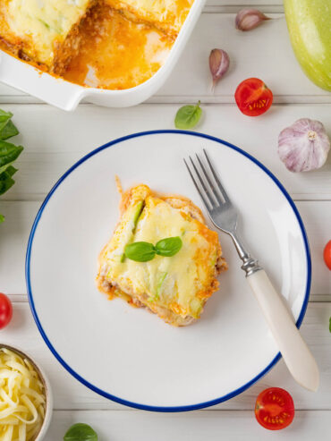 Zucchini-Lasagne Stück auf Teller mit Basilikum