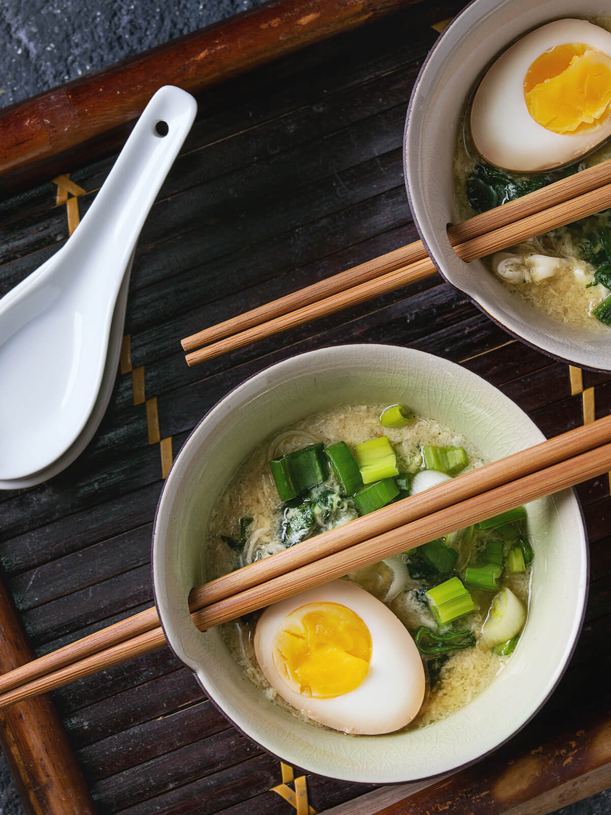 Asiatische Eier-Spinat-Suppe mit halbiertem Ei und Frühlingszwiebeln