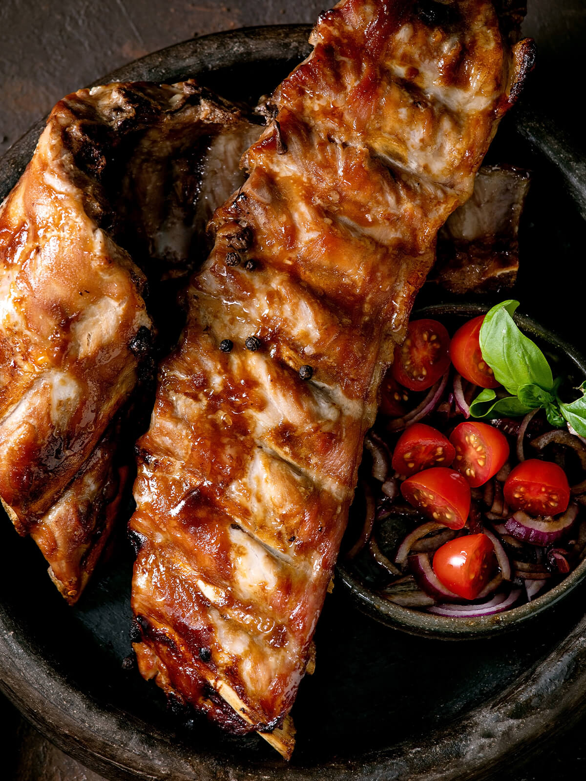 Spareribs aus dem Ofen mit dunkler BBQ-Glasur und Tomaten-Zwiebel-Salat
