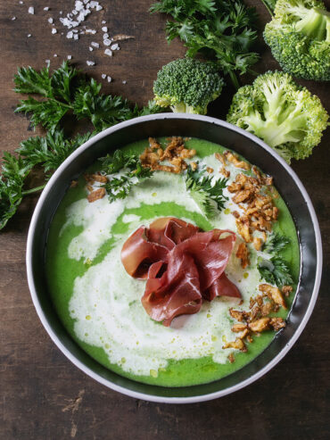 Brokkoli-Cremesuppe mit Serrano-Schinken-Rose und grob frittierten Zwiebel-Nestern