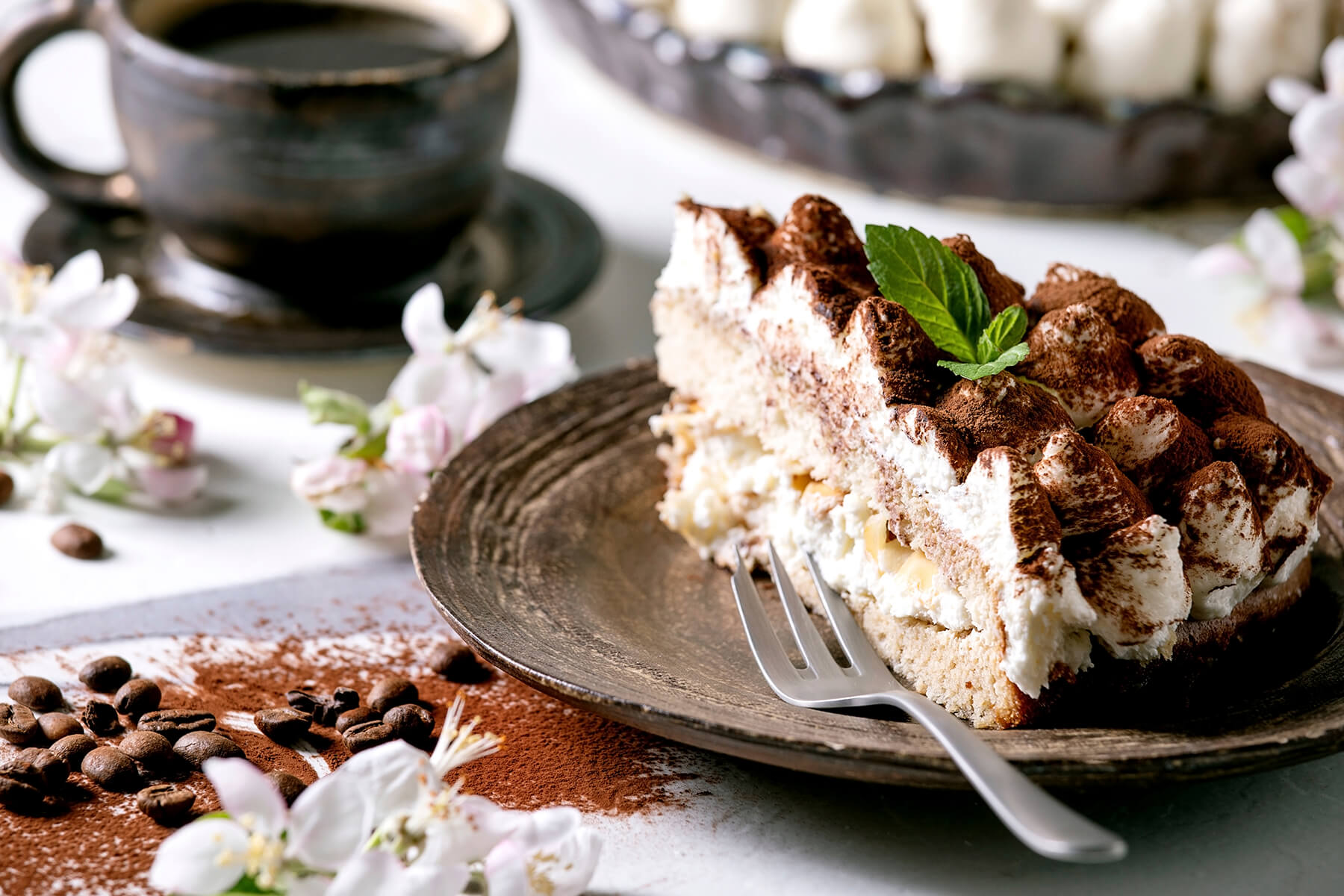 Anschnitt der glutenfreien Tiramisu-Torte mit hellem Reis-Biskuit unten, dicker Cremeschicht und zweitem Boden