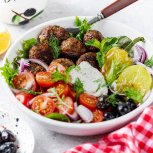 Griechische Keftedes-Bowl mit Tzatziki, Paprika, Tomaten und Oliven