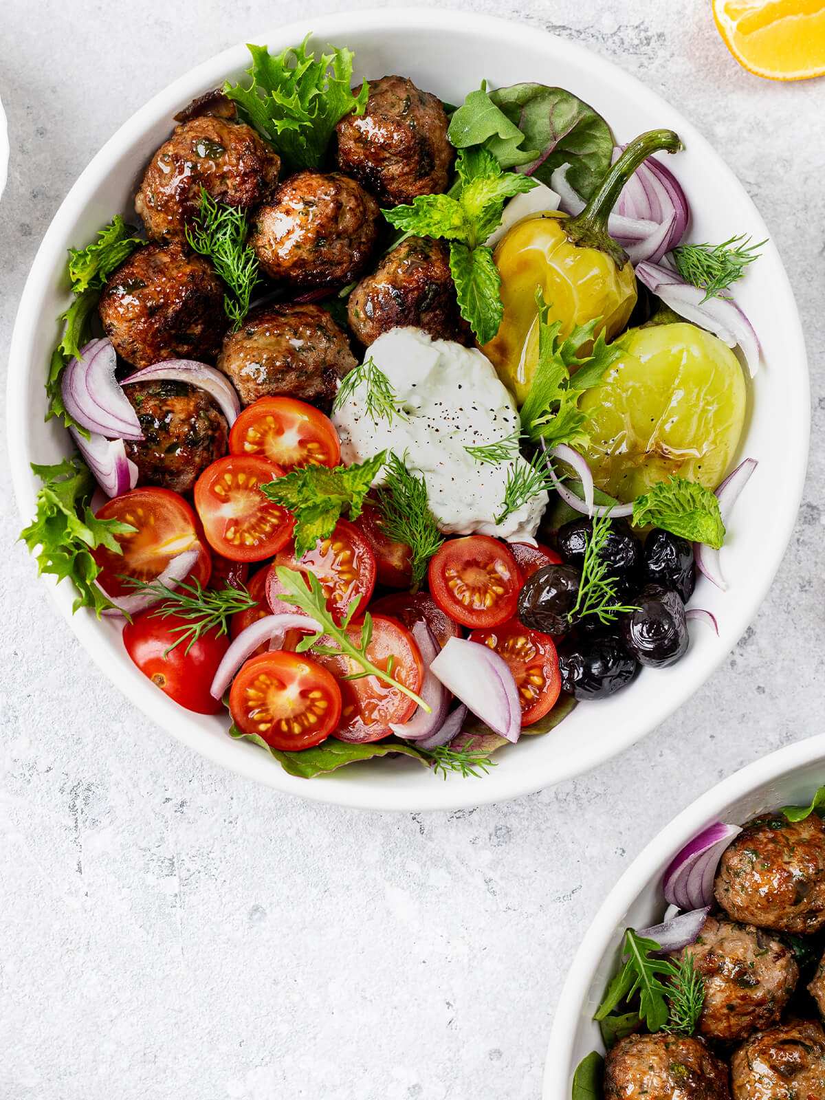 Griechische Keftedes-Bowl mit Tzatziki, gebratener Paprika, Kirschtomaten und Oliven