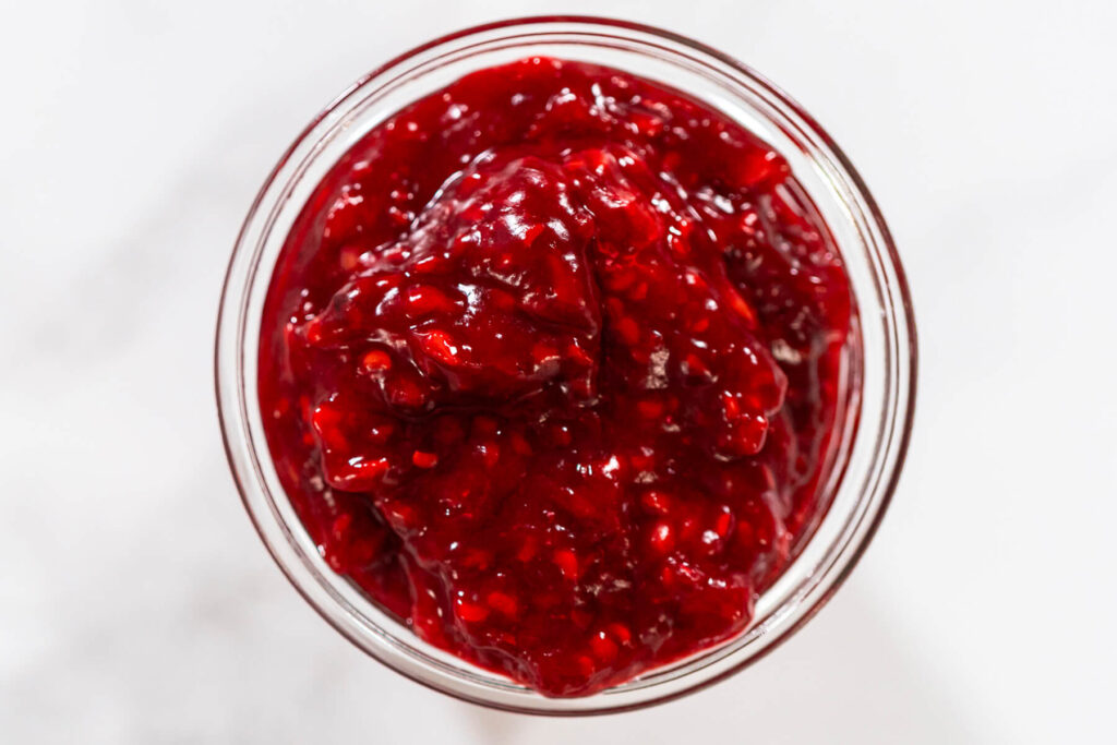 Himbeer-Tortenfüllung im Glas, dickflüssig und glänzend rot