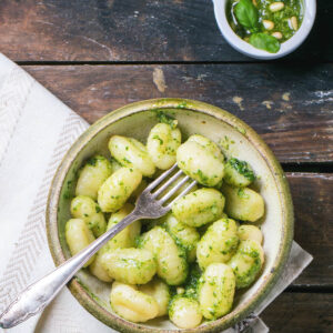 Kartoffel-Gnocchi mit Pesto in einer Keramikschale, daneben ein Schälchen Basilikum-Pesto mit Pinienkernen