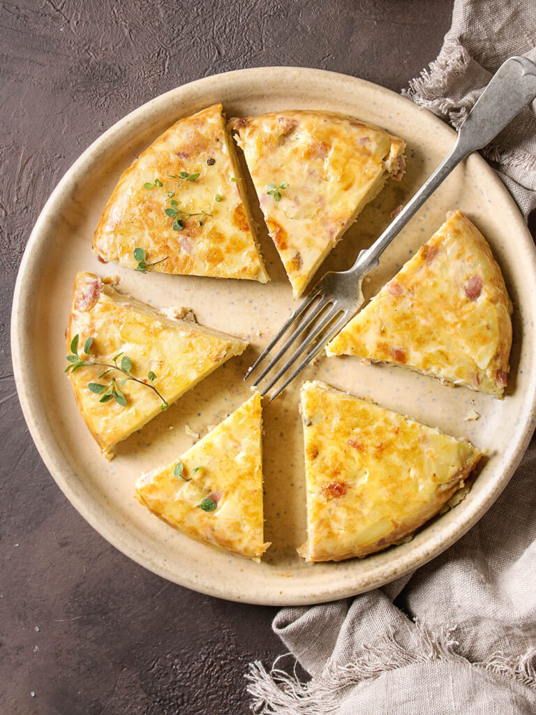 Kartoffel-Tortilla mit Speck in Tortenstücken