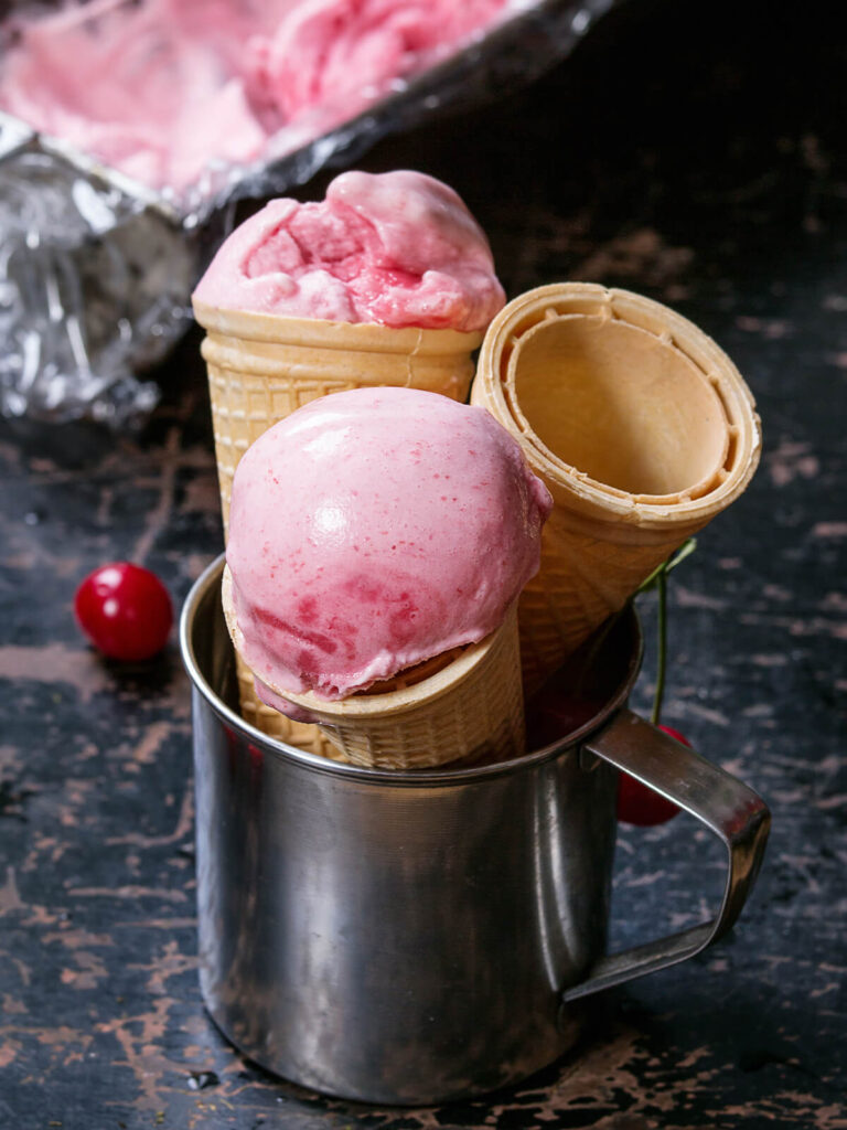 Zwei Kugeln Kirsch-Sorbet in Waffeltüten im Gelateria-Stil