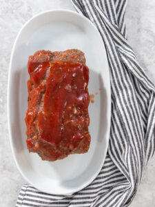 Klassischer Hackbraten mit süßer Glasur auf dem Servierteller