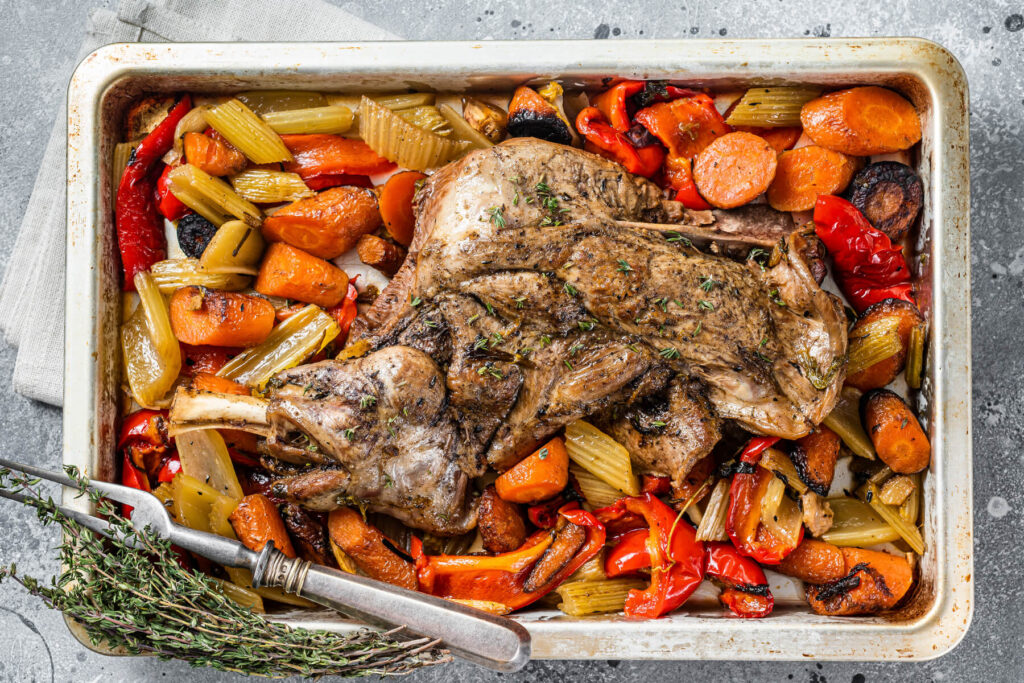 Lammschulter mit Wurzelgemüse von oben fotografiert – das ganze Blech mit Möhren, Sellerie, Paprika und Lammschulter darüber