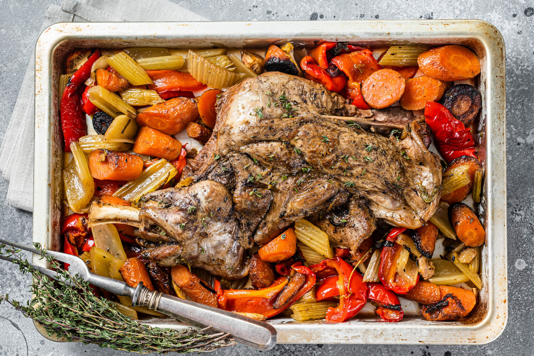Lammschulter mit Wurzelgemüse von oben fotografiert – das ganze Blech mit Möhren, Sellerie, Paprika und Lammschulter darüber