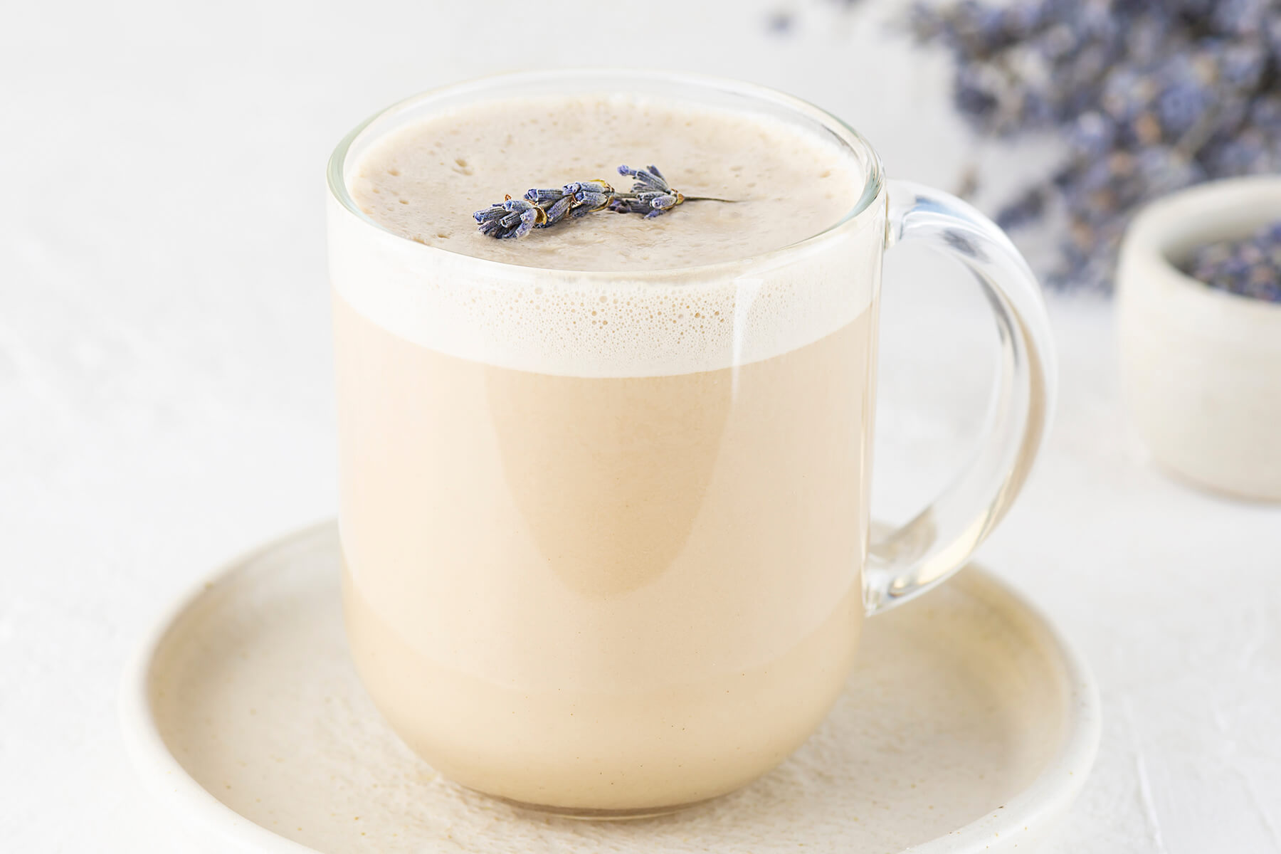 Lavendel-Latte mit feiner Schaumstruktur und getrockneten Lavendelblüten