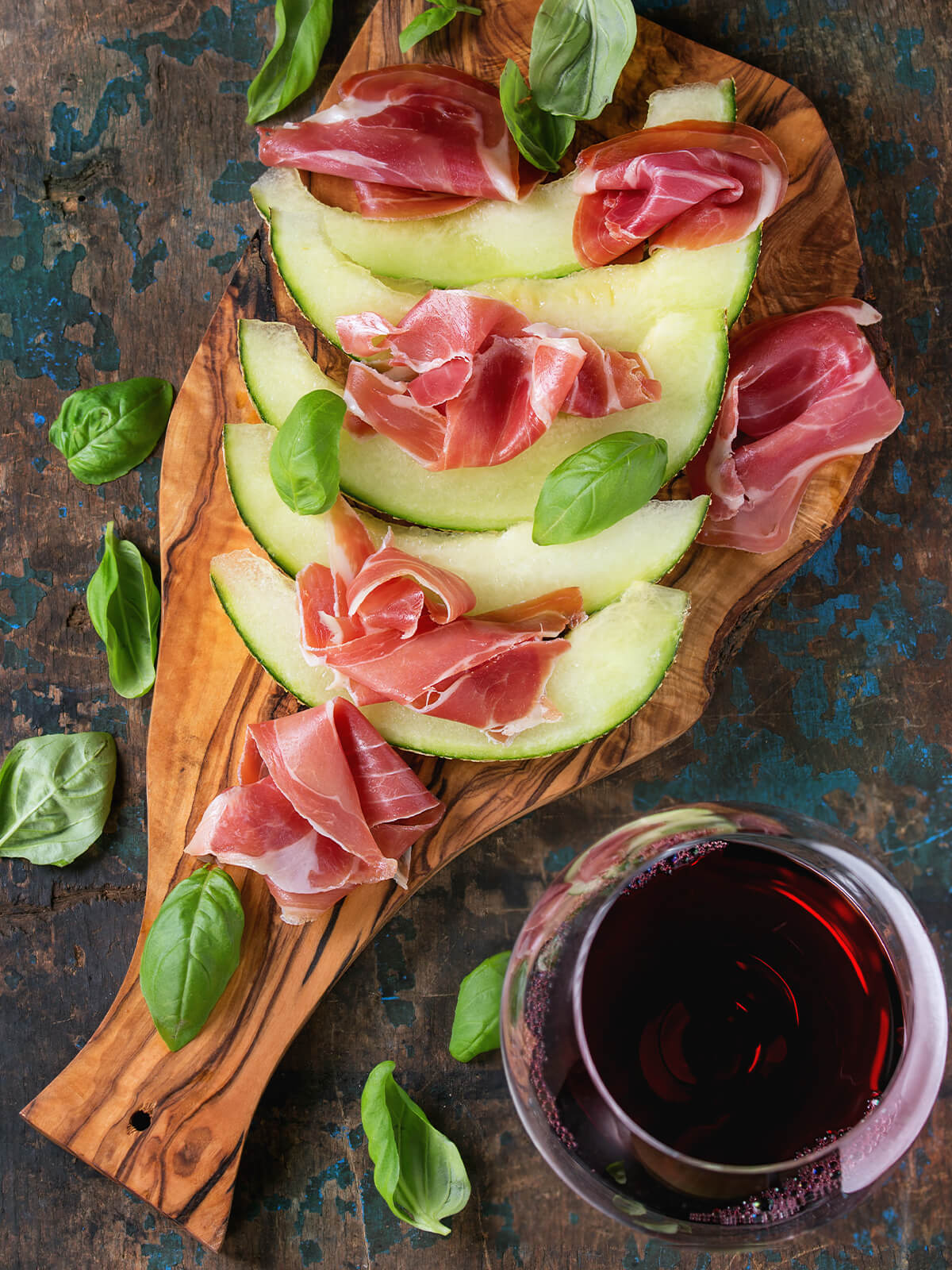 Melone mit Prosciutto Crudo italienisches Sommer-Antipasto auf Holzbrett mit Basilikum und Rotwein