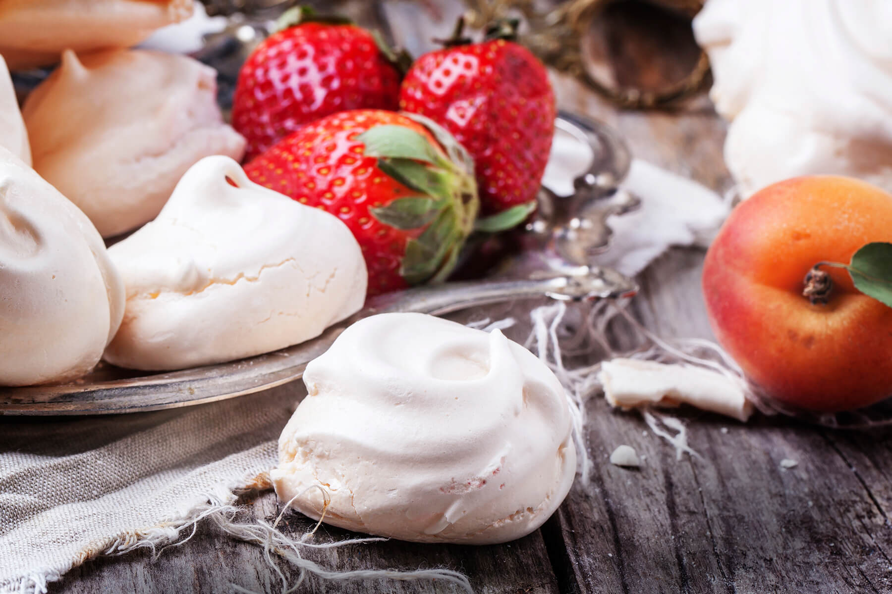 Schneeweiße französische Meringue mit Erdbeeren und einer Aprikose als Dekoration