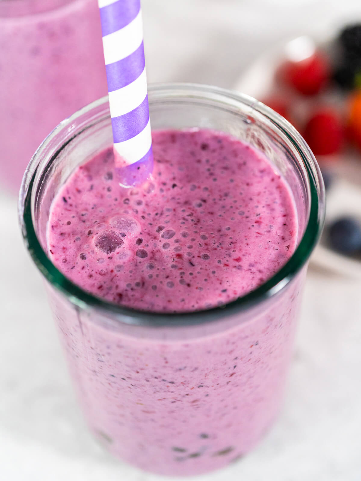 Aufsicht auf ein Glas Mixed-Berry-Boba-Smoothie mit cremig-violetter Oberfläche und breitem Strohhalm