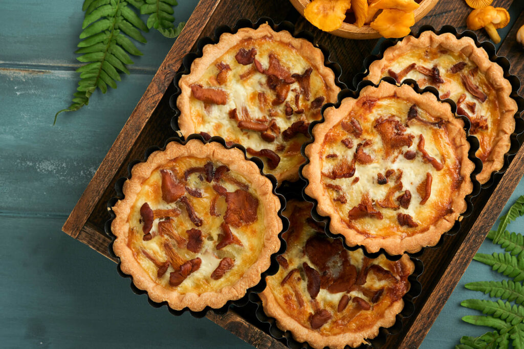 Offene Pfifferling-Tartelettes mit hellem Käse-Sahne-Guss und Pilzen obenauf
