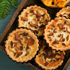 Offene Pfifferling-Tartelettes mit hellem Käse-Sahne-Guss und Pilzen obenauf