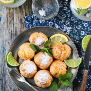 Profiteroles mit Puderzucker und Minze, dazu Zitronen-Limonade