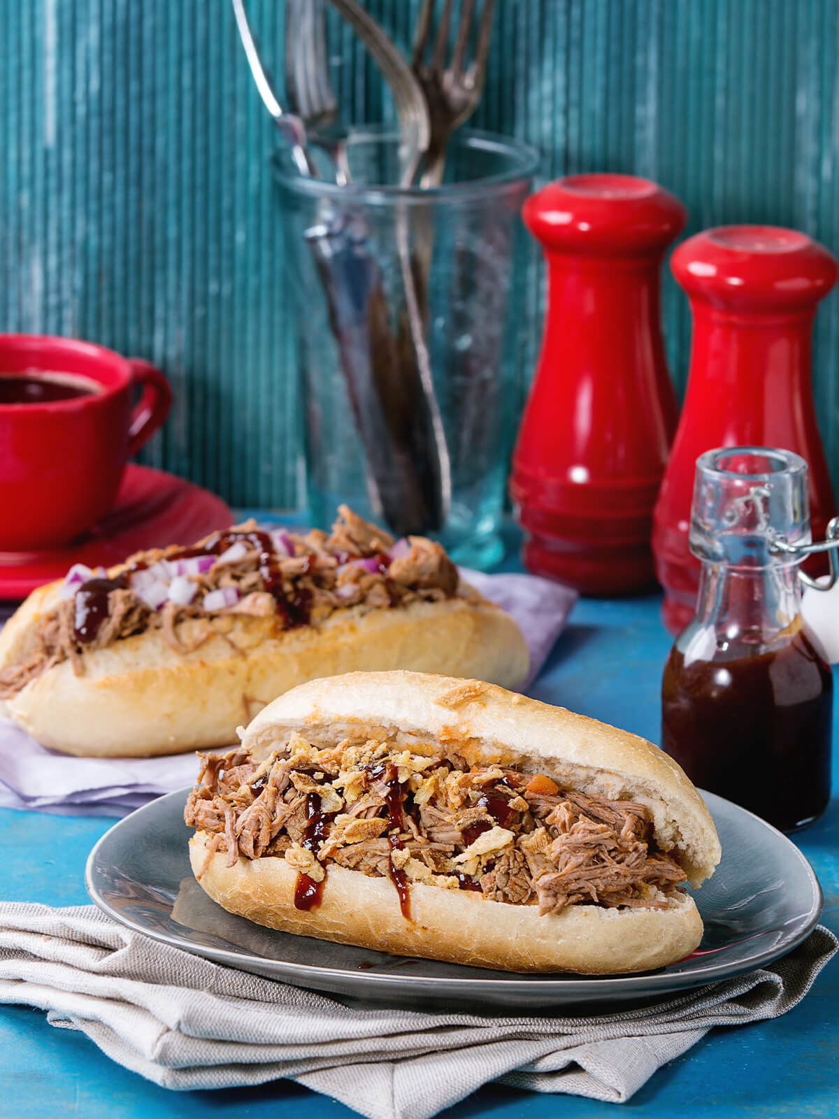 Zwei Pulled Pork Subs, einer mit Röstzwiebeln und roten Zwiebeln kombiniert