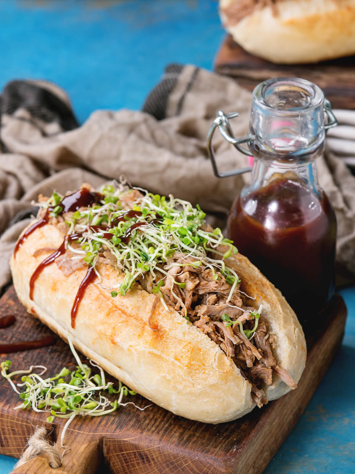 Langes Sub-Brötchen mit Pulled Pork und frischen grünen Sprossen