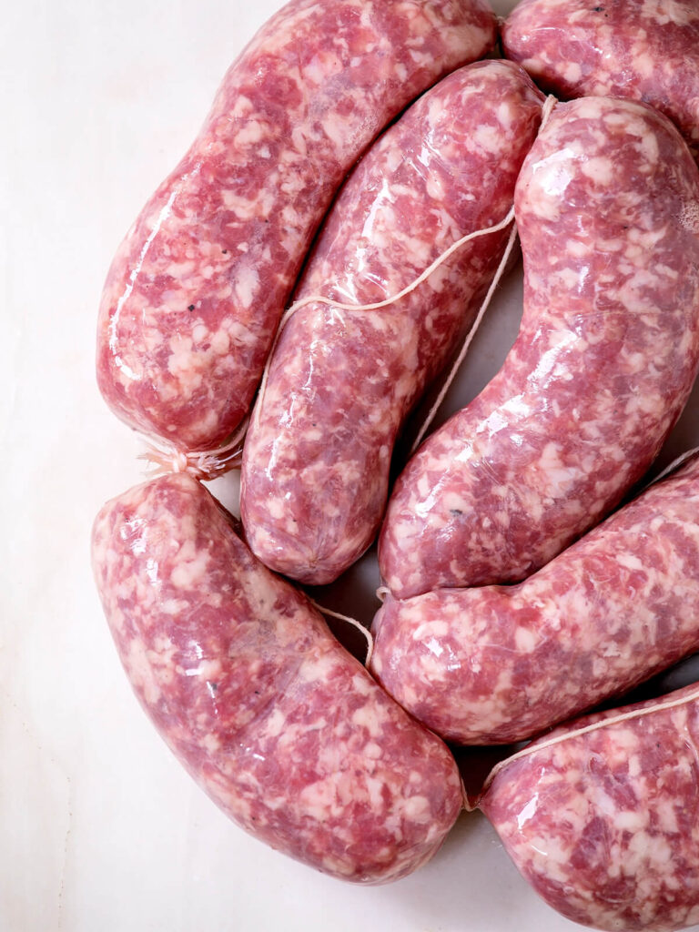 Gegrillte italienische Salsiccia mit Tomatensauce und frischem Salat – der Klassiker aus der Gusspfanne