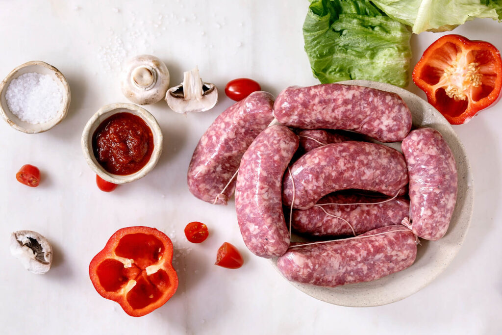Gegrillte italienische Salsiccia mit Tomatensauce und frischem Salat – der Klassiker aus der Gusspfanne