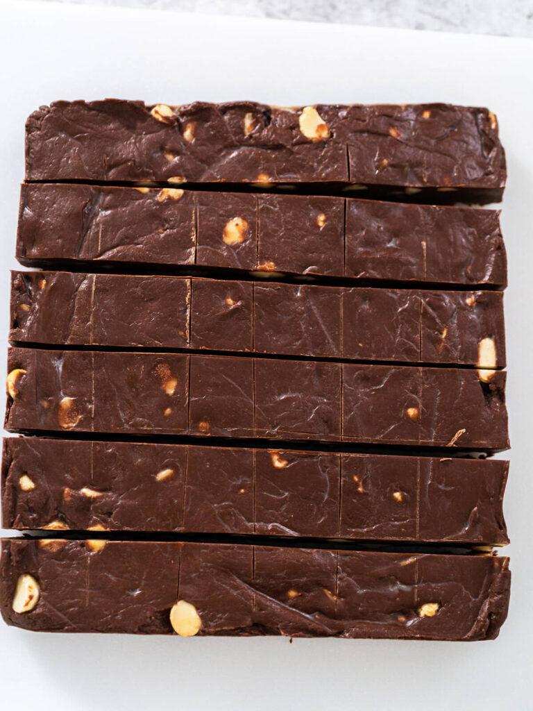 In Streifen geschnittener Schoko-Macadamia-Fudge auf weißem Untergrund