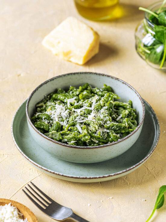 Schale mit grünen Tiroler Spinat-Spätzle, frisch geriebenem Parmesan und Olivenöl