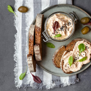 Thunfisch-Rillettes im Bügelglas mit dunklem Landbrot, grünen Oliven und schwarzem Sesam
