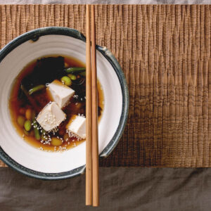 Tofu-Miso-Suppe mit Wakame, grünen Bohnen und Edamame in dunkler Schale