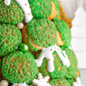 Weihnachts-Croquembouche aus grünen Craquelin-Windbeuteln mit weißem Zuckerguss und goldenen Zuckerperlen