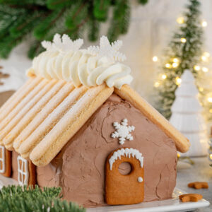 Weihnachts-Schoko-Hauskuchen mit Löffelbiskuit-Dach und Puderzucker