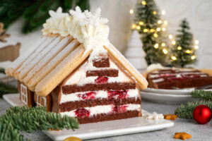 Angeschnittener Schoko-Hauskuchen mit Sahne-Kirsch-Schichten und Tannenzweigen