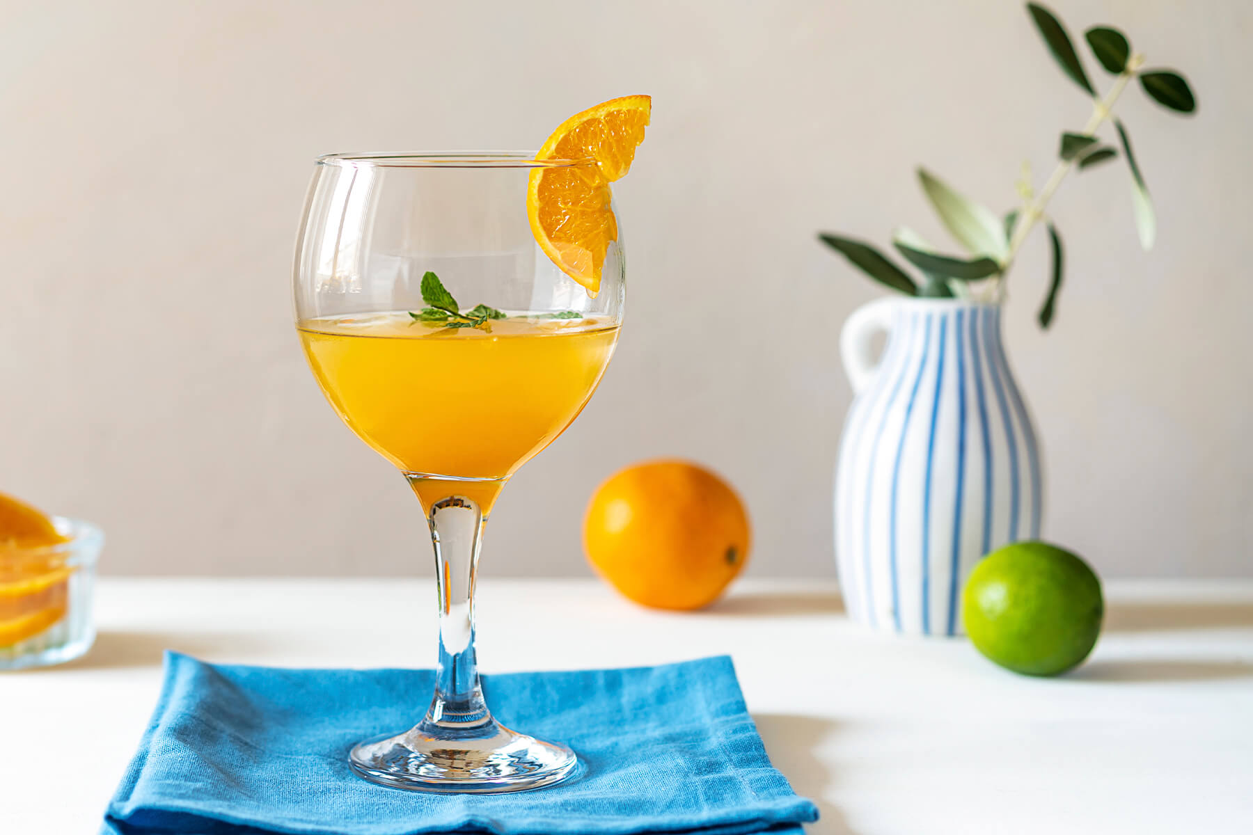 Yellow Bird Cocktail goldgelb im Stielglas mit Eiswürfeln und Orangenscheibe