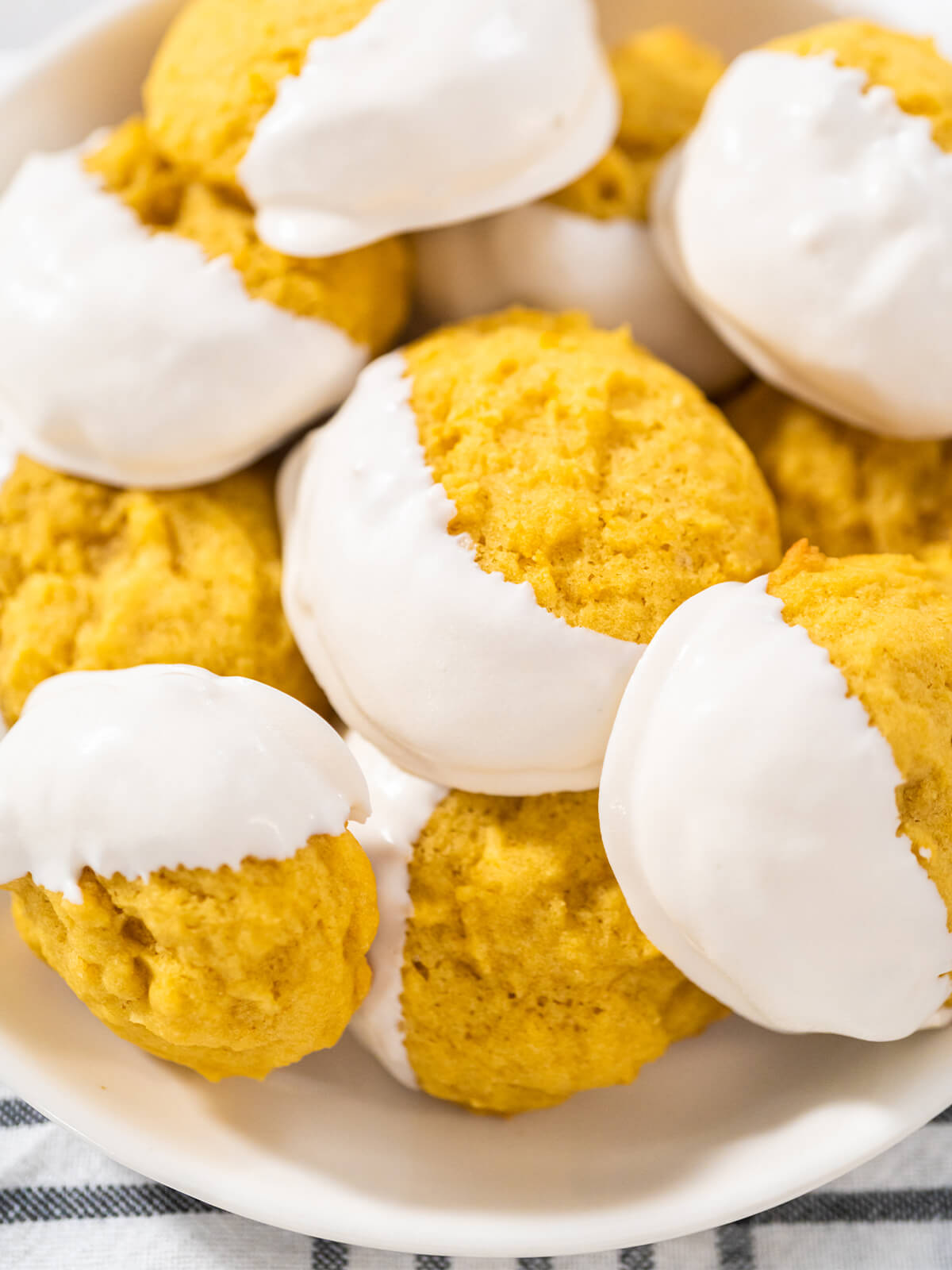 Weiche Zitronen-Cookies halb in weißer Schokolade getaucht