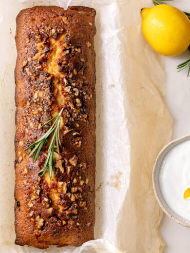 Zitronen-Pound-Cake mit knuspriger Walnusskruste und Rosmarin von oben, daneben Zitrone und Joghurt-Creme