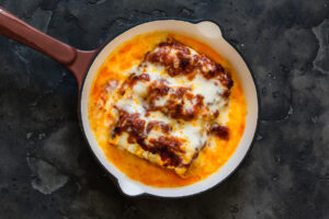 Goldbraun überbackene Zucchini-Cannelloni mit Mozzarella in der Pfanne