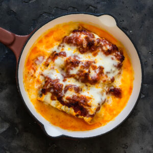 Goldbraun überbackene Zucchini-Cannelloni mit Mozzarella in der Pfanne