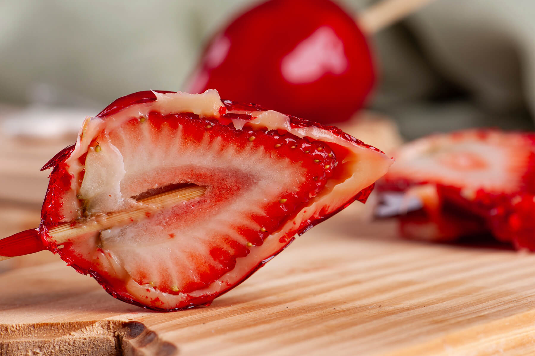 Aufgeschnittene Morango do Amor in Großaufnahme – saftige Erdbeere, weiße Cremeschicht und dünne rote Zuckerhülle