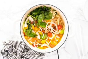 Vegetarische One-Pot-Pasta mit Spaghetti, bunten Kirschtomaten, geriebenem Hartkäse und frischem Basilikum