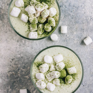 Warmer Matcha-Latte mit Kokosmilch von oben fotografiert, mit Mini-Marshmallows belegt und mit grünem Matcha bestäubt