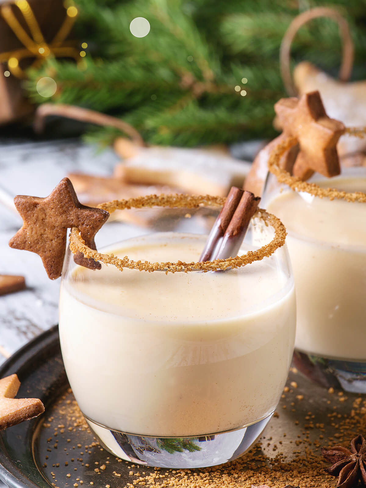 Cremiger Weihnachts-Eierpunsch im Glas mit Zimt-Zucker-Rand, Zimtstange und einem Zimtstern als Garnitur