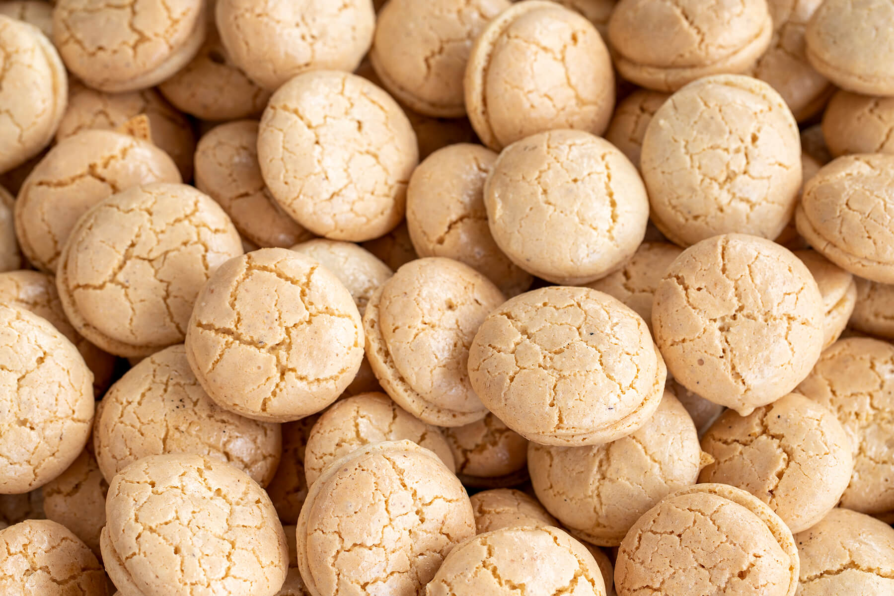 Viele türkische Mandelkekse mit goldener Rissoberfläche von oben, dicht nebeneinander