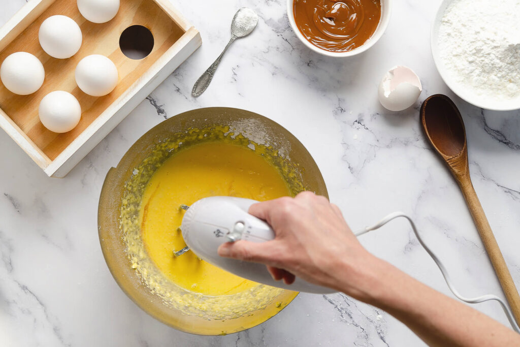 Eigelbmasse wird in einer Schüssel mit dem Handmixer glatt aufgeschlagen