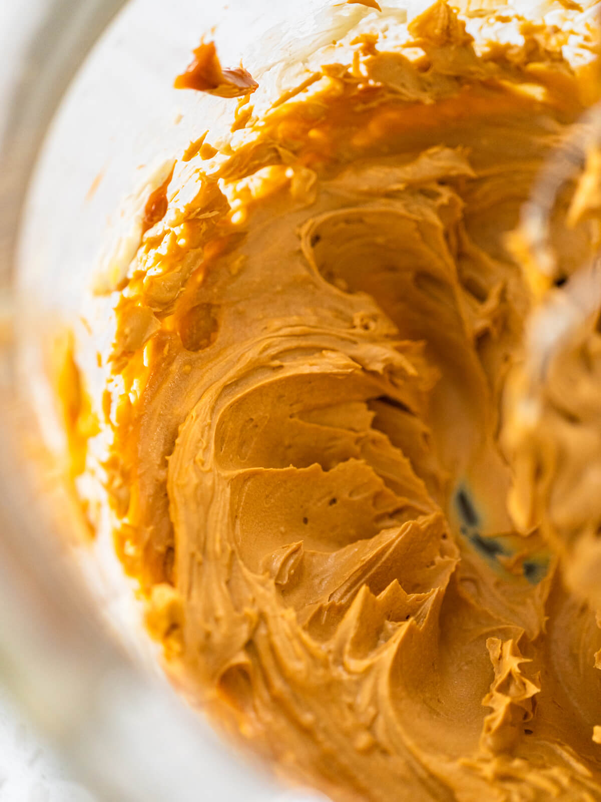 Nahaufnahme der glatten, glänzenden karamellfarbenen Dulce-de-Leche-Buttercreme in einer Schüssel