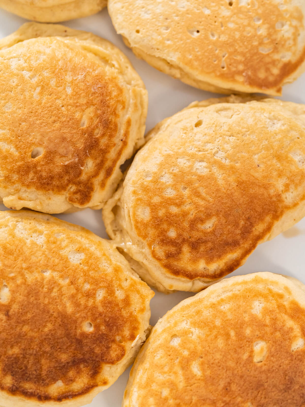 Nahaufnahme mehrerer fluffiger, goldbraun gebackener Eierlikör-Pfannkuchen dicht an dicht